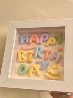 a white frame with the words happy birthday spelled out in small letters and teddy bears