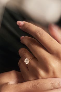 a woman's hand with a diamond ring on it