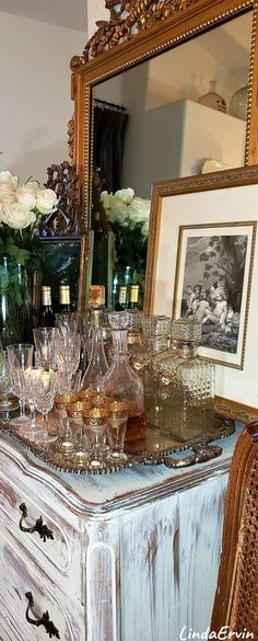 an old dresser with wine glasses on it