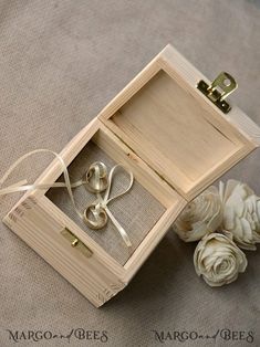 an open wooden box with two pairs of scissors in it next to some white flowers