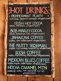 a menu for hot drinks on a wooden board with writing in english and latin letters