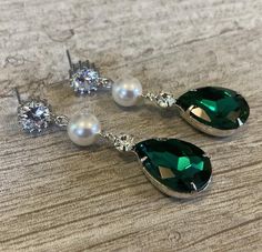 Long Green Earrings Emerald Green Rhinestone Earrings Pear Shape with Swarovski Pearl wedding bridal jewelryThese  Bridal Earrings in Emerald Green Crystal Rhinestone are so pretty with a Long Green Pear Shaped Drop that measures a total of  2 inches long. Made with a Swarovski Pearl in your choice of color either White (shown) or Cream Ivory, these also have a CZ Rhinestone post on the top.Comes in a Gift Box and ready to give. Perfect wedding bridal or gift!To see more Bridal Wedding Jewelry v Green Crystal Rhinestone Earrings For Wedding, Green Rhinestone Crystal Earrings For Wedding, Wedding Green Crystal Rhinestone Earrings, Emerald Green Crystal, Emerald Green Earrings, Earrings Emerald, Historical Jewellery, Wedding Bridal Jewellery, Green Crystal