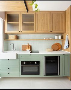 a kitchen with green cabinets and white counter tops