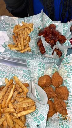 three baskets filled with fried food on top of paper wrappers next to each other