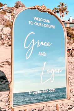 a welcome sign on the beach for a wedding