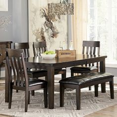 a dining room table with chairs and a rug