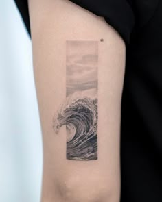 a person with a tattoo on their arm that has a wave coming out of it