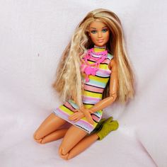 a doll sitting on the ground with her legs crossed