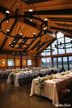 the inside of a large room with tables and chairs set up for an elegant dinner