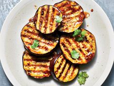 grilled eggplant slices on a plate with cilantro