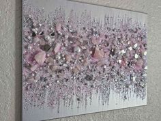 an abstract painting with pink and silver glitters on the bottom, along with white walls