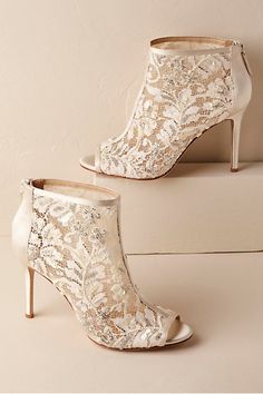 a pair of wedding shoes on top of a white table next to a wall with the words bridal shoes