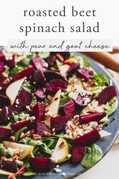 roasted beet spinach salad with pears and goat cheese on a blue plate