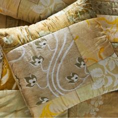 a close up view of some pillows on a bed with yellow and white designs in them