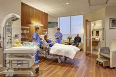 two men in scrubs are talking to each other in a room with medical equipment