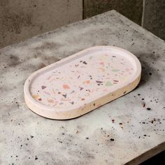 a white tray with sprinkles on it sitting on top of a table