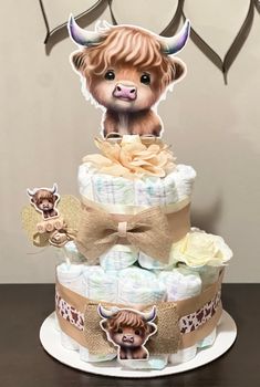 a three tiered diaper cake with a baby cow on it's top