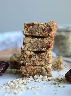 granola bars stacked on top of each other with raisins scattered around them