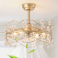 a gold chandelier with white flowers hanging from it