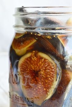 a jar filled with sliced figs on top of a table