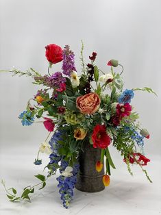 a vase filled with lots of different colored flowers