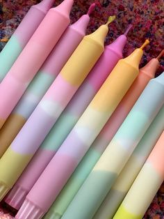 several pastel colored pens lined up in a row next to each other on a carpet