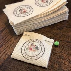 several napkins are stacked on top of each other with green pins in the middle