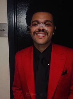 a man in a red suit with fake moustache on his face