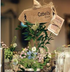 there is a sign that says catbells on it and flowers in vases