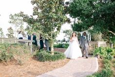 the bride and groom are walking down the path