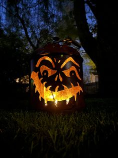 a pumpkin lantern is lit up in the dark with an evil face carved into it