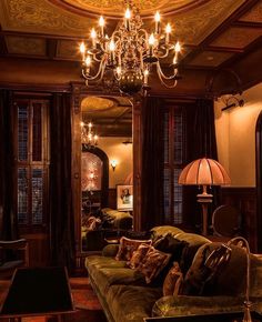 a living room filled with furniture and a fancy chandelier hanging from the ceiling