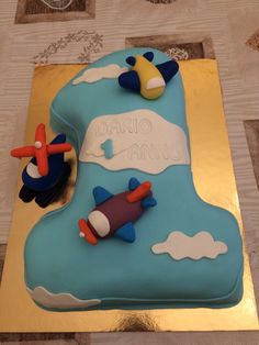 there is a cake that looks like an airplane on the ground with clouds and stars