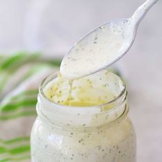 a spoon full of dressing sitting on top of a jar