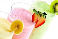 three glasses filled with different types of smoothies and fruit on top of each other