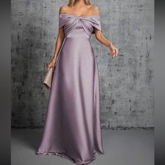 a woman in a long purple dress posing for the camera with her hand on her hip