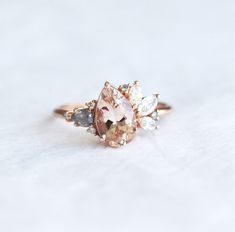 an engagement ring with two pear shaped morganite and three diamond accented stones in rose gold