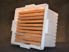 a stack of wooden planks sitting inside of a white container