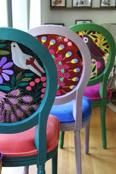 four colorful chairs sitting on top of a hard wood floor