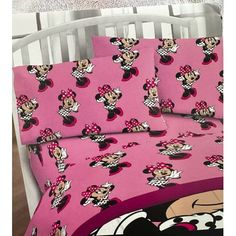 a bed with pink sheets and mickey mouse bedspreads on top of each other