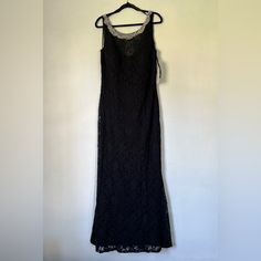 a black lace dress hanging on a white wall