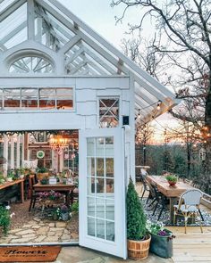 a small white house sitting on top of a wooden deck