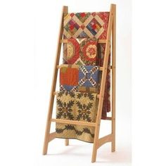 a wooden stand with quilts on it