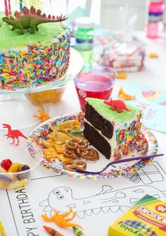 a birthday cake with sprinkles is on a table next to other party foods