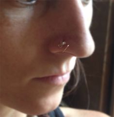 a close up of a person with a nose piercing on their left side of the ear