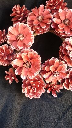 a wreath made out of pink flowers on a black background