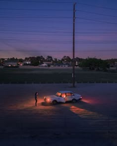 a person standing next to a parked car at night