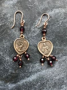 Sacred Heart and Scapular Earrings Bronze wire and medals Garnet gemstones Catholic Jewelry, Jewelry Lookbook, Garnet Gemstone, Jewelry Inspo, Sacred Heart, Pretty Jewellery, Heart Jewelry, Star Earrings, Piercing Jewelry