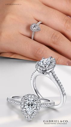 a woman's hand holding two engagement rings