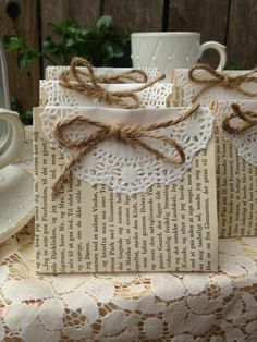 two pieces of paper tied with twine on top of a table next to a cup and saucer